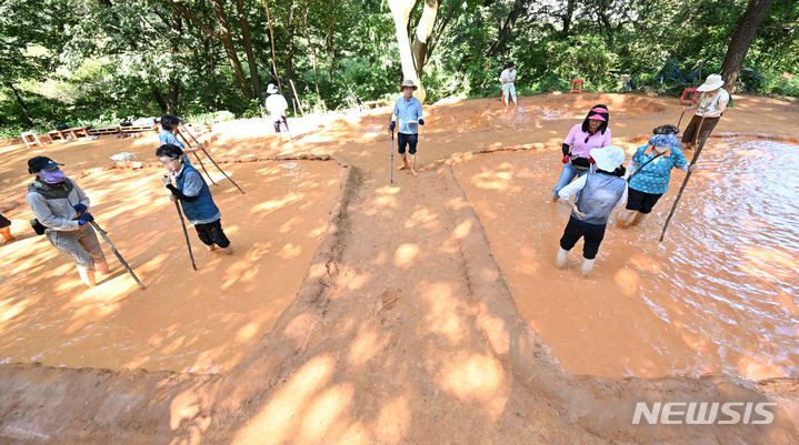 [광주=뉴시스] 김혜인 기자 = 6일 오전 광주 서구 풍암호수 황톳길에서 주민들이 족욕을 하고 있다. 2023.09.06. hyein0342@newsis.com