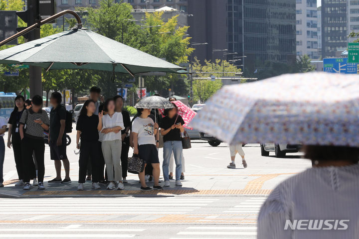 [서울=뉴시스] 권창회 기자 =  11일 월요일은 전국이 흐린 가운데 낮 최고기온은 31도까지 올라 후텁지근하겠다. 제주도 등 전국 곳곳엔 약한 비가 내리겠다. 사진은 늦더위가 이어지고 있는 지난 7일 오후 서울 종로구 광화문역 인근에서 시민들이 햇빛을 피해 그늘에서 신호대기를 하는 모습. 2023.09.07. kch0523@newsis.com