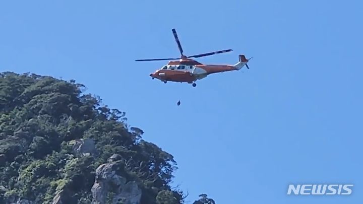 [제주=뉴시스] 지난 2023년 9월8일 오전 제주 서귀포시 산방산에서 하산 중이던 등산객 2명이 길을 잃어 소방헬기 한라매에 의해 구조되고 있다. (사진=제주서부소방서 제공) 2023.09.08. photo@newsis.com
