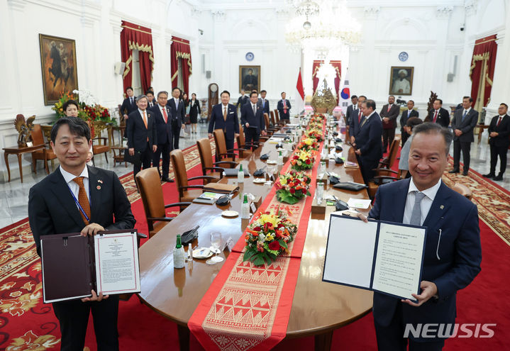 [자카르타=뉴시스] 전신 기자 = 안덕근 통상교섭본부장과 아구스 구미왕 카르타사스미타 인도네시아 산업부 장관이 8일(현지시간) 자카르타 대통령궁에서 윤석열 대통령과 조코 위도도 인도네시아 대통령이 임석한 가운데 열린 한-인도네시아 MOU 서명식에서 산업협력에 관한 양해각서를 체결하고 있다. 2023.09.08. photo1006@newsis.com