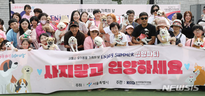 [서울=뉴시스] 황준선 기자 = 10일 오후 서울 강동구의 한 상가에서 열린 '서울시 유기동물 가족의 날 엔조이 섬머 반려동물 입양파티'에서 입양된 유기 반려견과 입양가족들이 기념촬영을 하고 있다. 2023.09.10. hwang@newsis.com