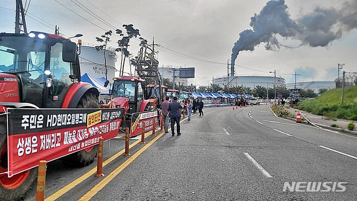 [서산=뉴시스] 송승화 기자 = 충남 서산시 대산읍에 있는 현대오일뱅크 공장 정문 앞에서 '페놀수 불법 배출 혐의' 관련, 12일 인근 마을 주민 800여명이 모인 시위 현장 뒤로 공장 굴뚝에서 수증기를 내뿜고 있다. 2023.09.12. ssong1007@newsis.com