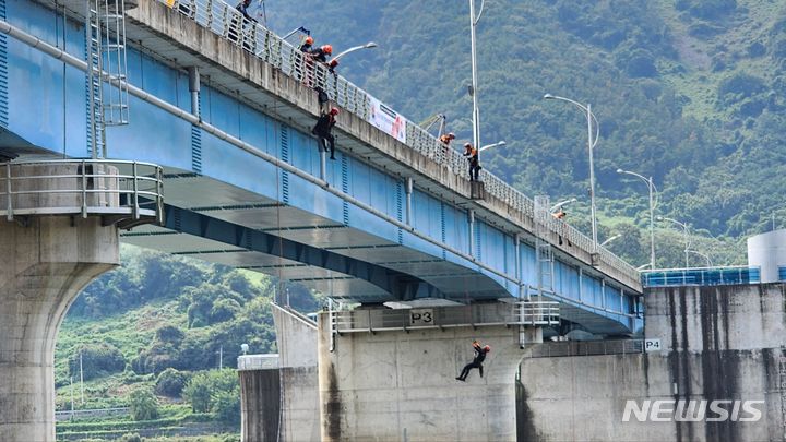 [창녕=뉴시스] 홍정명 기자=12일 경남 창녕군 길곡면 창녕함안보에서 규모 7.2 강진이 발생해 건설 중인 높이 20m 교각이 붕괴됐다는 가상 상황을 설정한 '영남권역 119특수대응단 지진대비 대응 수난사고 합동훈련'이 진행되고 있다.(사진=경남소방 제공) 2023.09.12. photo@newsis.com