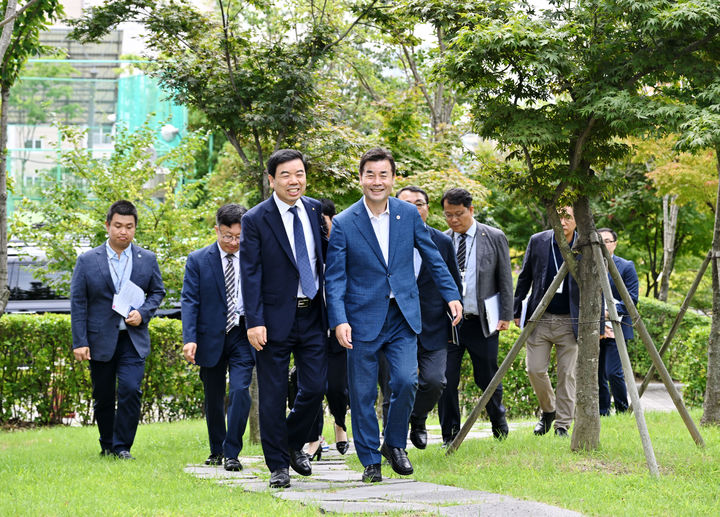 [울산=뉴시스] 울산 중구와 근로복지공단이 12일 근로복지공단 스마트룸에서 ‘누구나 살고 싶은 정원도시 조성 및 탄소중립 실천을 위한 업무협약’을 맺었다. 김영길 중구청장과 박종길 근로복지공단 이사장 등 공단 산책길을 걷고 있다. 2023.09.12. *재판매 및 DB 금지