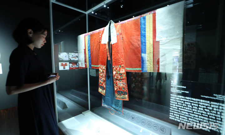 [서울=뉴시스] 최진석 기자 = 13일 서울 종로구 국립고궁박물관에서 열린 특별전시 ‘활옷만개-조선왕실 여성 혼례복’ 언론공개회에서 관계자가 그룹 '방탄소년단' 멤버 RM의 후원으로 복원된 조선시대 혼례복인 '활옷'을 살펴보고 있다. 이번 전시는 국립고궁박물관 2층 기획전시실에서 15일부터 12월 13일까지 진행된다. 2023.09.13. myjs@newsis.com