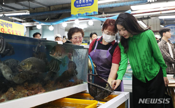 [부산=뉴시스] 홍효식 기자 = 윤석열 대통령 부인 김건희 여사가 14일 부산 기장군 기장시장을 방문해 상인이 뜰채로 건져 올린 가자미를 바라보고 있다. 2023.09.14. yesphoto@newsis.com