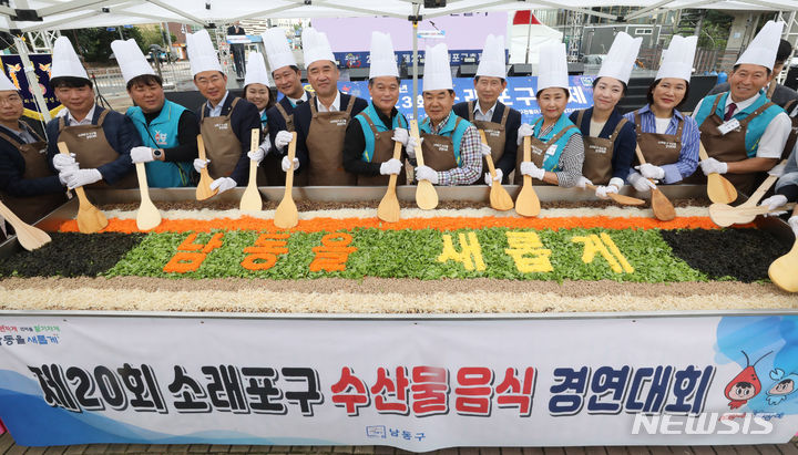 [인천=뉴시스] 전진환 기자 = 제23회 소래포구축제가 열린 15일 오전 인천 남동구 소래포구 해오름광장에서 맹성규 더불어민주당 의원,  박종효 남동구청장, 오용환 남동구의회의장 등 참석자들이 대형 비빔밥을 비비는 퍼포먼스를 하고 있다.  2023.09.15. amin2@newsis.com