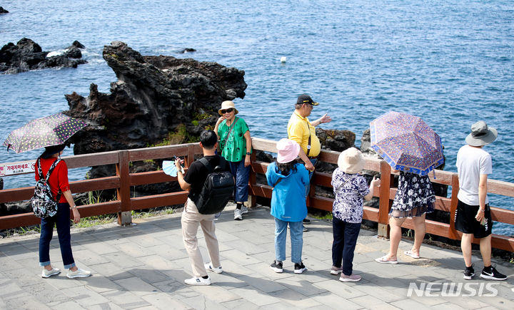 [제주=뉴시스] 우장호 기자 = 제주 시내권 대표적인 관광지 용두암을 찾은 중국인 단체관광객들이 기념촬영을 하며 즐거운 시간을 보내고 있다. (사진=뉴시스DB) woo1223@newsis.com