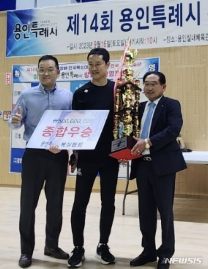  공학배 회장(사진 오른쪽)이 신찬울 경기운영위원장과 함께 우승을 차지한 김윤곤 동백복싱체육관장(가운데)에게 시상하고 있다. 용인시복싱협회 제공