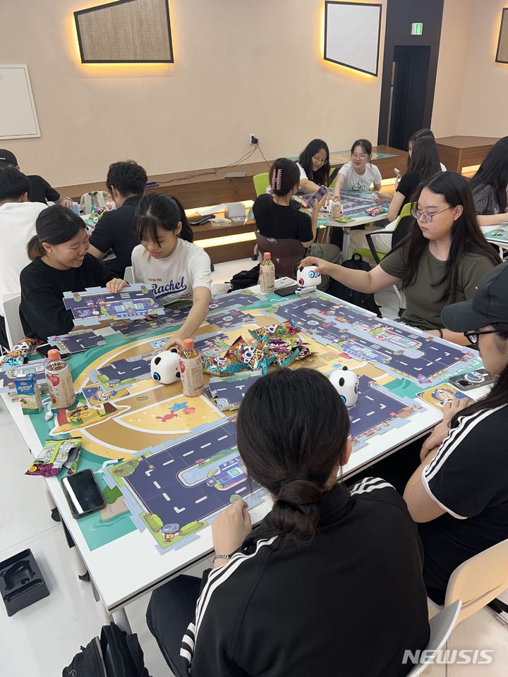 [창원=뉴시스] 홍정명 기자=마산대학교 'Digital literacy(디지털 리터러시) UP' 프로그램에 참여한 재학생들이 미니 코딩 로봇을 활용한 달리기 시합을 하고 있다.(사진=마산대 제공)2023.09.18. photo@newsis.com