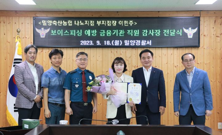 김병주 밀양경찰서장이 전화금융사기 피해 예방에 이바지한 밀양축산농협 나노지점 A직원에게 감사장을 수여, 기념촬영을 하고 있다. (사진=밀양경찰서 제공) *재판매 및 DB 금지