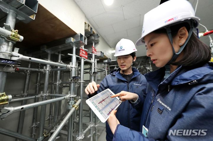 [서울=뉴시스] 대우건설 연구원들이 '실시간 동바리 붕괴위험 모니터링 시스템'을 테스트하고 있다. (사진=대우건설 제공)