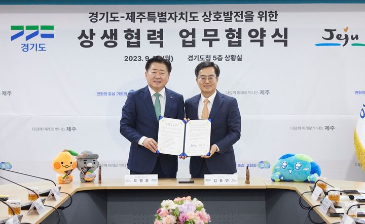 [수원=뉴시스] 18일 오후 경기도청 상황실에서 열린 경기-제주 상생협력 업무협약식에서 김동연 경기도지사와 오영훈 제주도지사가 합의문에 서명 후 기념촬영을 하고 있다.(사진=경기도 제공) *재판매 및 DB 금지