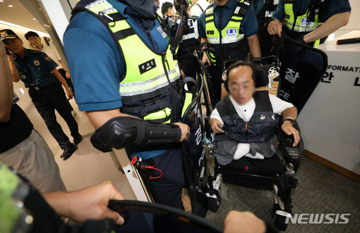 [서울=뉴시스] 황준선 기자 = 18일 오전 서울 중구 장애인고용공단 서울지역본부에서 점거농성을 벌이던 전국장애인차별철폐연대(전장연) 회원이 경찰에 의해 연행되고 있다. 2023.09.18. hwang@newsis.com