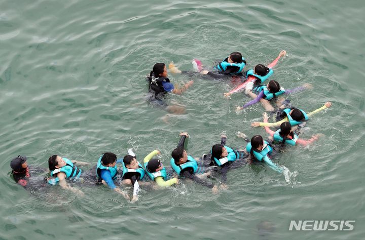 [부산=뉴시스] 하경민 기자 = 부산 여고초등학교 학생들이 18일 오전 수영구 광안리해수욕장 앞바다에서 생존수영을 배우고 있다. 동래교육지원청은 이번 주 관내 초등학교 3곳의 5·6학년 학생 100여 명을 대상으로 광안리해양레포츠센터에서 '초등학생 바다 생존수영교육 체험'을 운영한다. 2023.09.18. yulnetphoto@newsis.com