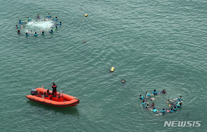 [부산=뉴시스] 하경민 기자 = 부산 여고초등학교 학생들이 18일 오전 수영구 광안리해수욕장 앞바다에서 생존수영을 배우고 있다. 동래교육지원청은 이번 주 관내 초등학교 3곳의 5·6학년 학생 100여 명을 대상으로 광안리해양레포츠센터에서 '초등학생 바다 생존수영교육 체험'을 운영한다. 2023.09.18. yulnetphoto@newsis.com