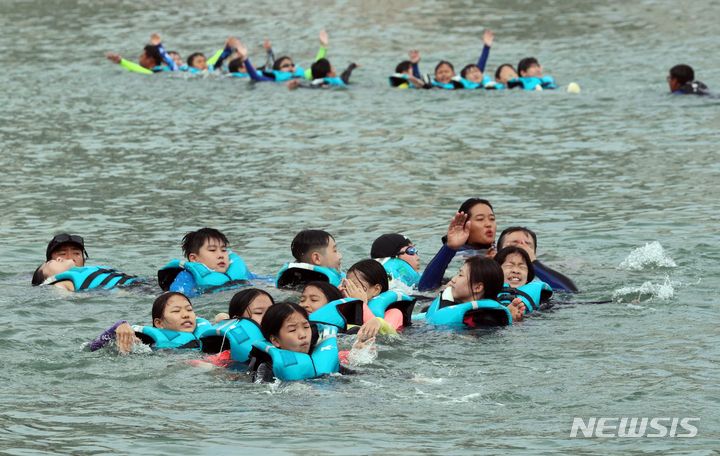 [부산=뉴시스] 하경민 기자 = 부산 여고초등학교 학생들이 18일 오전 수영구 광안리해수욕장 앞바다에서 생존수영을 배우고 있다. 동래교육지원청은 이번 주 관내 초등학교 3곳의 5·6학년 학생 100여 명을 대상으로 광안리해양레포츠센터에서 '초등학생 바다 생존수영교육 체험'을 운영한다. 2023.09.18. yulnetphoto@newsis.com