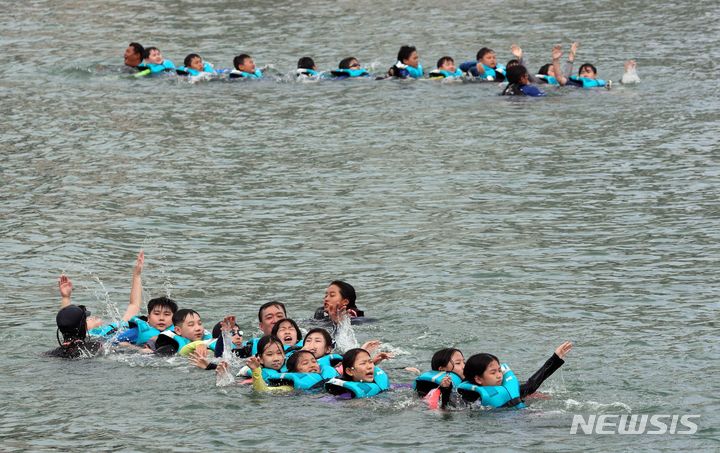 [부산=뉴시스] 하경민 기자 = 부산 여고초등학교 학생들이 18일 오전 수영구 광안리해수욕장 앞바다에서 생존수영을 배우고 있다. 동래교육지원청은 이번 주 관내 초등학교 3곳의 5·6학년 학생 100여 명을 대상으로 광안리해양레포츠센터에서 '초등학생 바다 생존수영교육 체험'을 운영한다. 2023.09.18. yulnetphoto@newsis.com