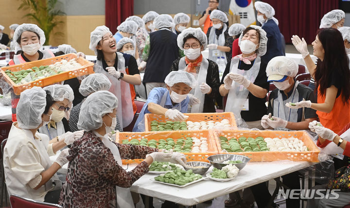 [과천=뉴시스] 김종택기자 = '2023년 추석맞이 사랑담은 송편으로 따뜻한 정(情)나누기 추석 행사'가 열린 19일 경기도 과천시청 대강당에서 자원봉사자 등 참석자들이 송편을 빚고 있다. 2023.09.19. jtk@newsis.com
