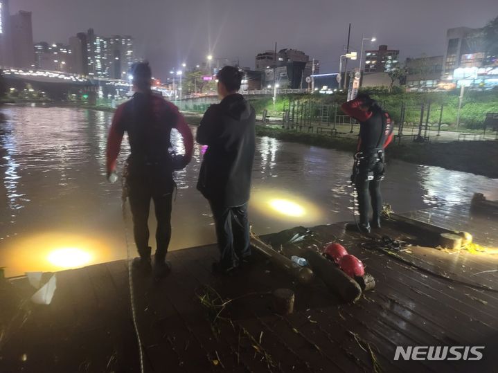 [부산=뉴시스] 권태완 기자 = 20일 오후 부산 금정구 부산도시철도 1호선 온천장역 인근 온천천 산책로에서 폭우로 인해 불어난 물에 고립된 한 여성이 기둥을 붙잡고 있다는 신고가 접수됐다. 신고를 받고 출동한 부산소방은 대원 100여 명과 원격수중탐사장비 등을 투입해 수색 작업을 벌이고 있다. (사진=부산소방재난본부 제공) 2023.09.20. photo@newsis.com