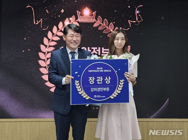 [창원=뉴시스]홍정명 기자=경남도청 최예지(오른쪽) 주무관이 행정안전부 지방자치인재개발원 류임철 원장으로부터 행정안전주 장관상을 받고 기념촬영을 하고 있다.(사진=경남도 제공)2023.09.21. photo@newsis.com