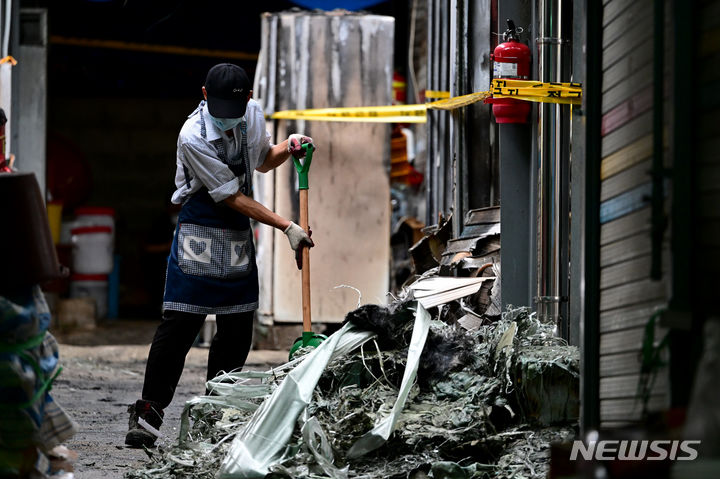 [광주=뉴시스] 이영주 기자 = 21일 오전 광주 광산구 비아5일장에서 전날 오후 발생한 상가 화재 피해를 겪은 상인이 불탄 잔해를 정리하고 있다. 비아5일장에서는 지난 20일 오후 6시 58분께 불이 나 상가 10동(89.7㎡)이 타거나 그을리고 소방서 추산 1900만원 상당의 재산 피해가 났다. 2023.09.21. leeyj2578@newsis.com