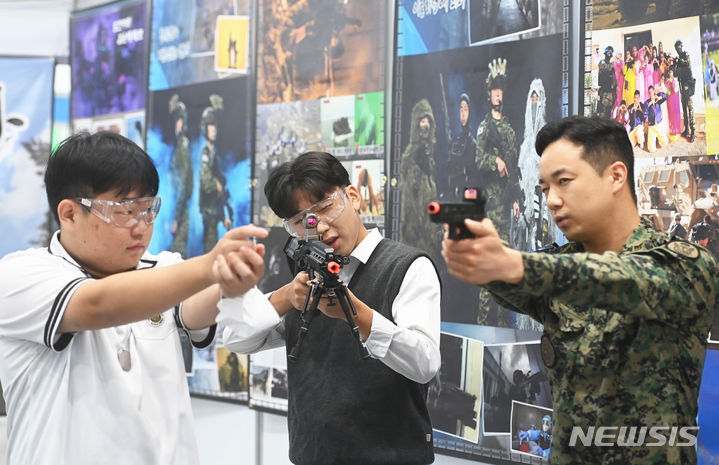 [수원=뉴시스] 김종택기자 = '2023 고졸채용박람회'가 열린 21일 경기도 수원시 권선구 수원메쎄에서 취업을 준비중인 고등학생들이 특전사 부스에서 사격 체험을 하고 있다. 2023.09.21. jtk@newsis.com