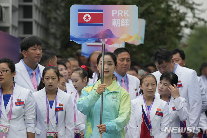 [항저우(중국 저장성)=AP/뉴시스]23일 개막하는 항저우 아시안게임을 하루 앞둔 22일 아시안게임 선수단 환영식에서 한 자원봉사자가 북한 인공기가 붙은 국가 팻말을 들고 있다. 세계반도핑기구(WADA)는 북한에 국제대회에서 국기 게양을 금지하는 제재를 부과하고 있는데, 항저우 아시아경기대회에서 22일 북한 국기 인공기가 게양돼 논란을 부르며, 주최국 중국에 책임을 묻거나 국제사회의 비판을 받게 될 가능성이 있다고 일본 지지 통신이 보도했다. 2023.09.22.