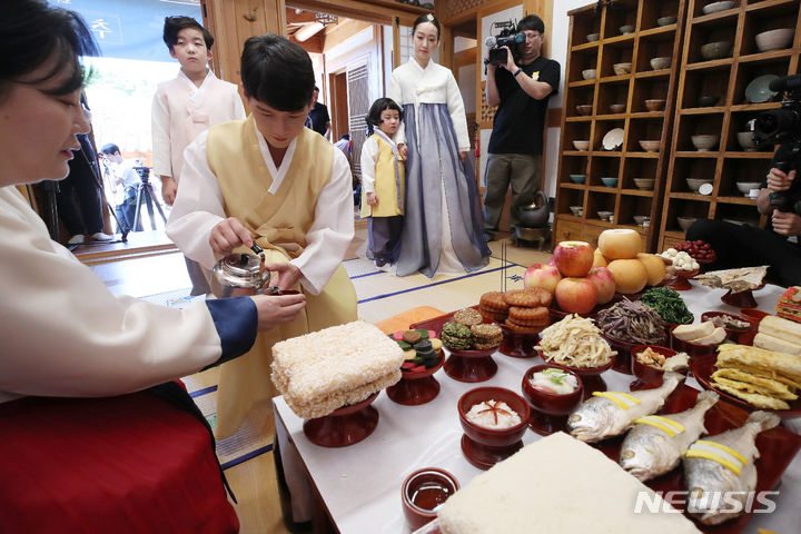 [서울=뉴시스] 조성우 기자 = 22일 오전 서울 은평구 은평한옥마을 예서헌에서 한국농수산식품유통공사(aT) 주최로 열린 추석 차례상 시연 행사에서 한복을 입은 4인 가족 모델들이 차례 시연을 하고 있다. 2023.09.22. xconfind@newsis.com