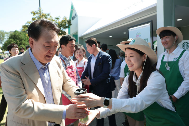 [서울=뉴시스] 윤석열 대통령이 추석을 앞둔 24일 서울 용산어린이정원에서 운영 중인 팔도장터를 방문해 음료를 받고 있다. (사진=대통령실 제공) 2023.09.24. photo@newsis.com *재판매 및 DB 금지