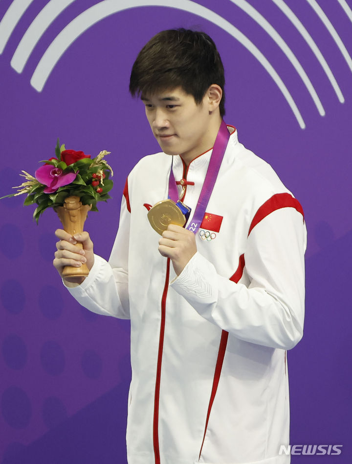 [항저우=뉴시스] 정병혁 기자 = 24일 중국 항저우 올림픽 스포츠센터 수영장에서 열린 2022 항저우 아시안게임 남자 자유형 100m 시상식에 금메달을 차지한 중국 판잔러가 메달을 목에 걸고 있다. 2023.09.24. jhope@newsis.com