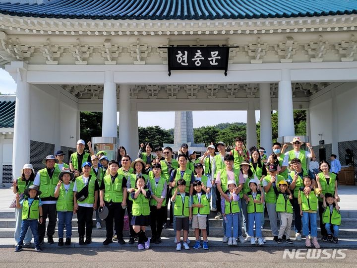 [서울=뉴시스] 현대엔지니어링 임직원과 임직원 가족이 지난 23일 '현충원 묘역 정화 봉사활동'을 진행하고 단체사진을 촬영하고 있다.(사진=현대엔지니어링 제공)