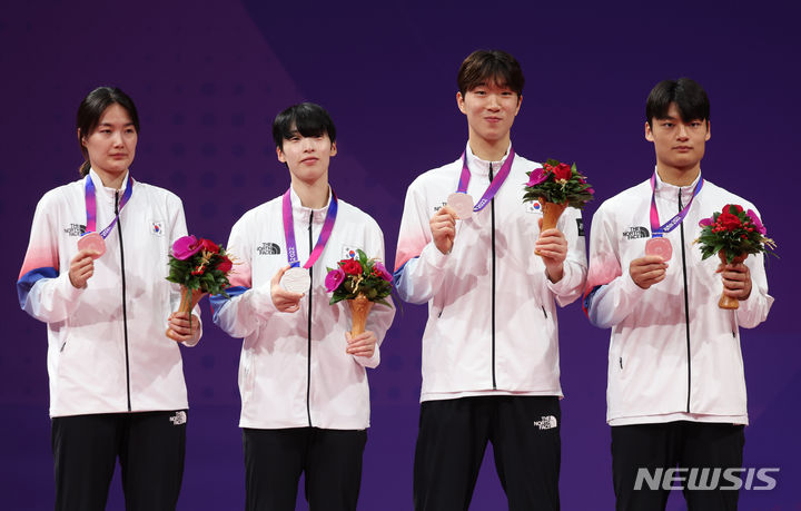 [항저우=뉴시스] 고승민 기자 = 25일 중국 항저우 린안 스포츠문화전시센터에서 열린 2022 항저우 아시안게임 태권도 남녀혼성 단체전에서 은메달을 딴 한국 선수들이 시상식에서 기념촬영하고 있다. 왼쪽부터 김잔디, 이다빈, 박우혁, 서건우. 2023.09.25. kkssmm99@newsis.com