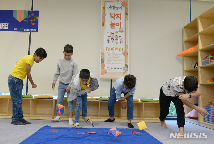 [울산=뉴시스] 배병수 기자 = 추석 명절을 앞둔 지난 2023년 9월 26일 울산 동구 화정가족문화센터 3층에서 열린 아프가니스턴특별기여자와 함께하는 한가위 체험 한마당에서 어린이들이 딱지놀이 게임을 하고 있다. 2023.09.26. bbs@newsis.com