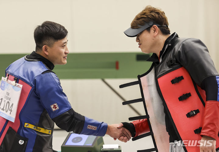 [항저우=뉴시스] 정병혁 기자 = 26일 중국 항저우 푸양 인후 스포츠센터에서 열린 2022 항저우 아시안게임 남자 10m 러닝타깃 혼합 개인 및 단체전 동점 슛오프 대한민국과 북한과의 경기에서 대결한 정유진과 북한 권광일이 악수를 하고 있다. 2023.09.26. jhope@newsis.com