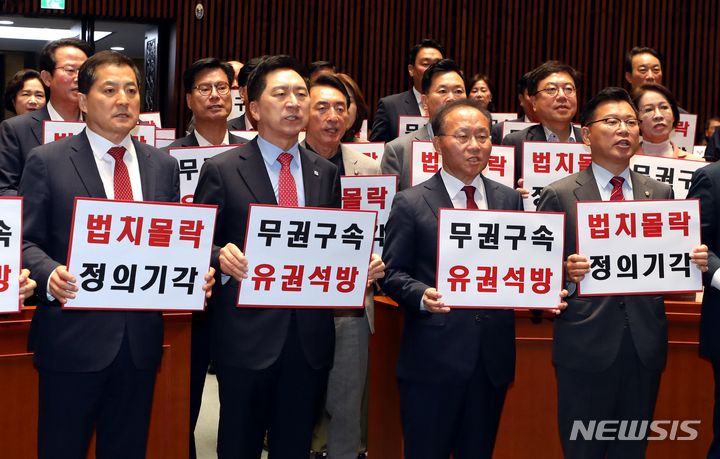 구호 외치는 국민의힘 김기현 대표와 윤재옥 원내대표.  [서울=뉴시스] 조성봉 기자 = 김기현 국민의힘 대표와 윤재옥 원내대표를 비롯한 의원들이 27일 오전 서울 여의도 국회에서 열린 비상 의원총회에서 '무권구속 유권석방' , '법치몰락 정의기각'이라고 적힌 피켓을 들고 구호를 외치고 있다. 2023.09.27. suncho21@newsis.com