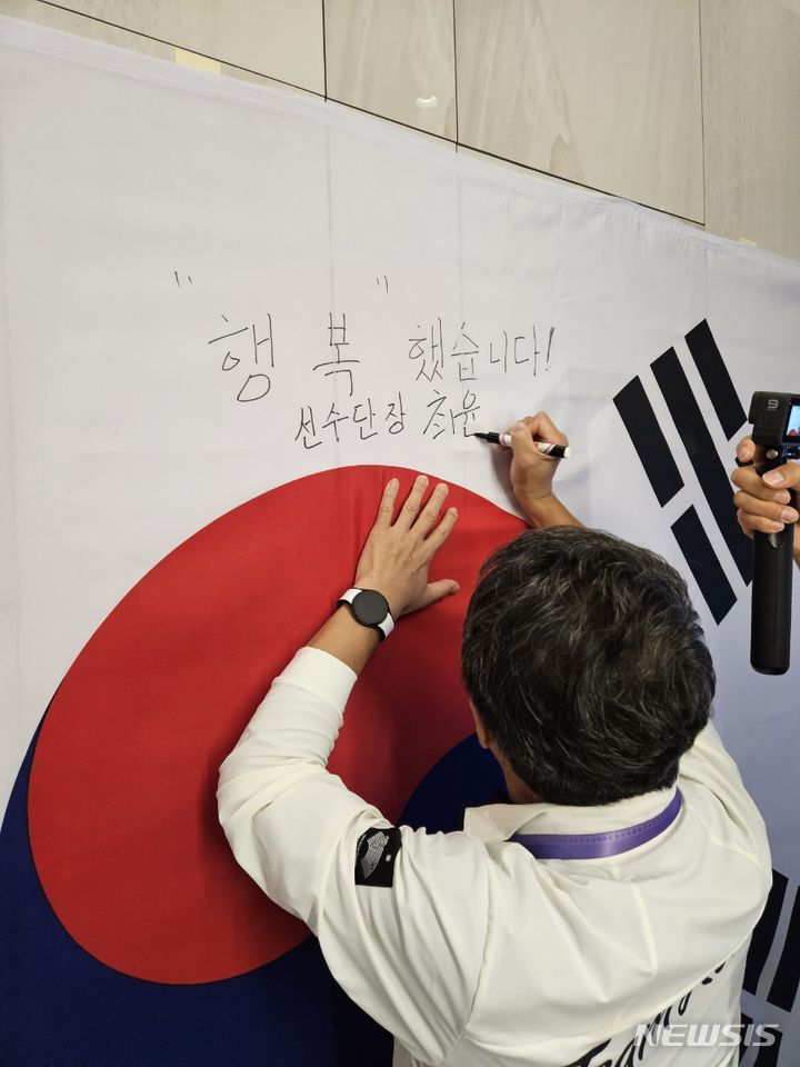 [서울=뉴시스] 최윤 2022 항저우아시안게임 한국 선수단장이 28일 항저우 선수촌에 설치된 메시지월에 "행복했습니다"라는 글귀를 적고 있다. *재판매 및 DB 금지 *재판매 및 DB 금지