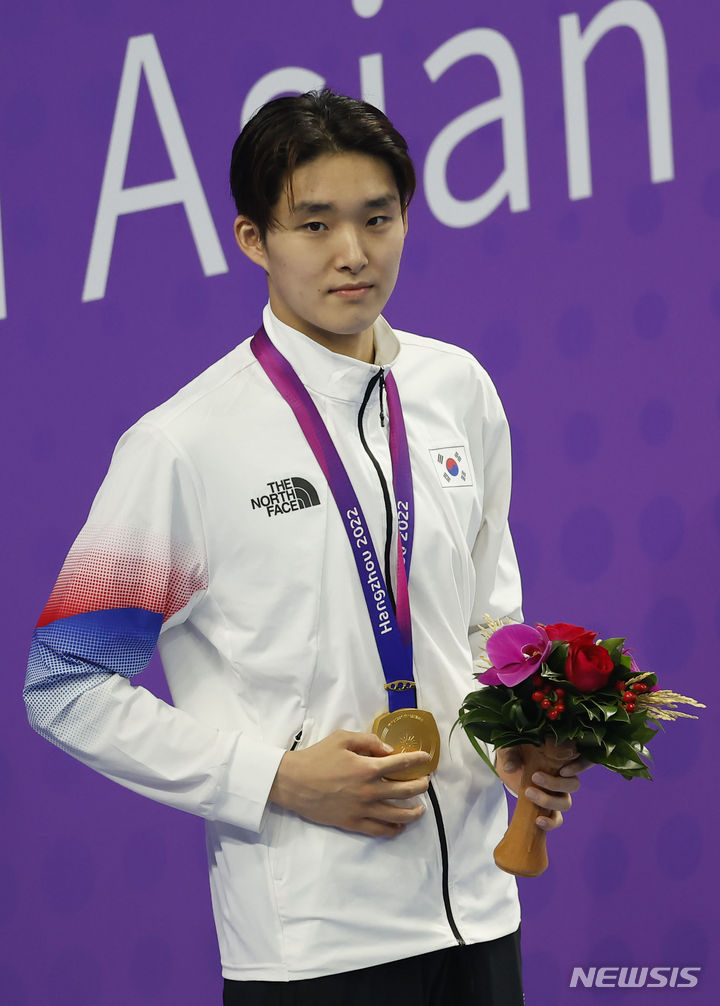 [항저우=뉴시스] 정병혁 기자 = 29일 중국 항저우 올림픽 스포츠센터 수영장에서 열린 남자 자유형 400m에서 금메달을 차지한 김우민이 메달을 목에 걸고 기뻐하고 있다. 2023.09.29. jhope@newsis.com