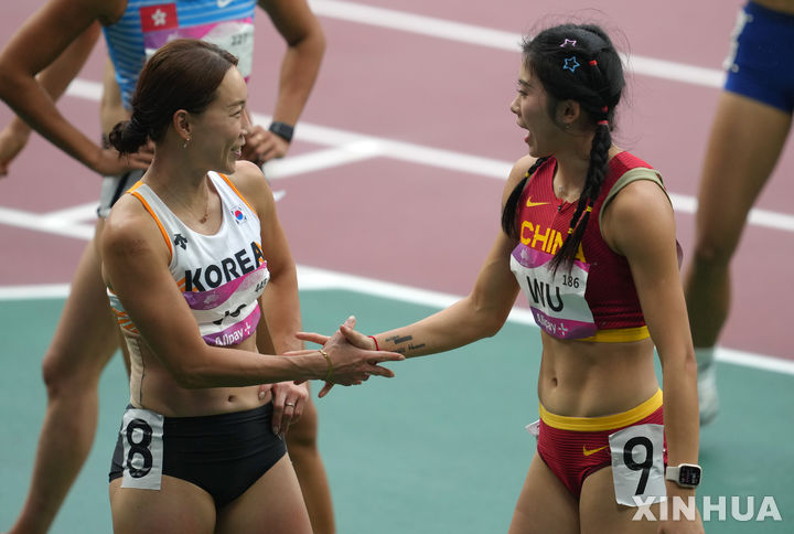 [항저우=신화/뉴시스] 1989년 6월4일 톈안먼 민주화 시위(톈안먼 사태)를 연상시키는 장면이 2022 항저우 아시안게임에서 우연히 연출돼 중국 관영 매체가 관련 사진을 삭제하는 일이 일어났다. 사진은 지난달 30일 항저우 아시안게임 여자 육상 100m 예선전에서 중국 선수 우옌니(오른쪽)와 조은주 선수가 인사하는 모습. 2023.10.05.