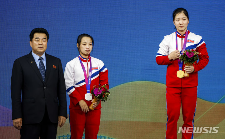 [항저우=뉴시스] 정병혁 기자 = 30일 중국 항저우 샤오산 스포츠센터에서 열린 2022 항저우 아시안게임 역도 여자 55kg급에서 금메달을 차지한 북한 강현경과 은메달을 차지한 리수연이 김일국 체육상과 기념촬영을 하고 있다. 2023.09.30. jhope@newsis.com