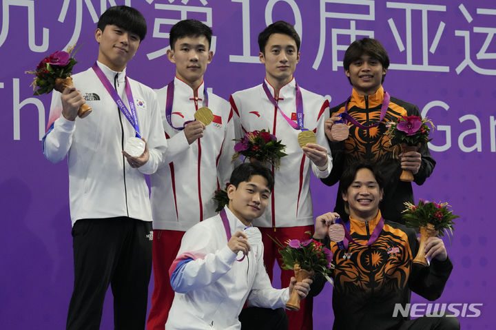 [항저우=AP/뉴시스] 김영남(제주도청)과 이재경(광주광역시체육회)이 1일 중국 저장성 항저우 올림픽 스포츠센터 수영장에서 열린 2022 항저우 아시안게임 다이빙 남자 싱크로 10m 플랫폼 결승에서 2위를 차지했다. 사진은 시상식에서 금메달을 딴 중국, 3위에 오른 말레이시아 조와 포즈를 취한 김영남과 이재경. 2023.10.01