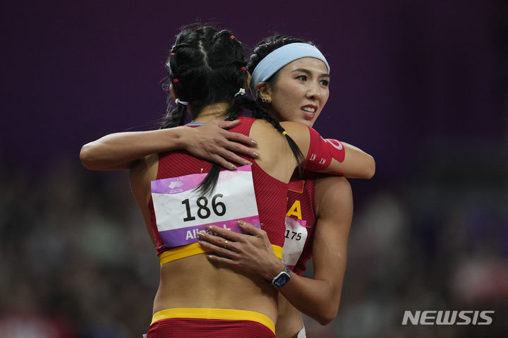 [항저우=AP/뉴시스] 1989년 6월4일 톈안먼 민주화 시위(톈안먼 사태)를 연상시키는 장면이 2022 항저우 아시안게임에서 우연히 연출돼 중국 관영 매체가 관련 사진을 삭제하는 일이 일어났다. 사진은 지난 1일 항저우 아시안게임 여자 육상 100m 허들 결승전 직후 금메달을 딴 중국 선수 린위웨이가 은메달리스트인 자국 동료 우옌니를 포옹하는 모습. 2023.10.05.