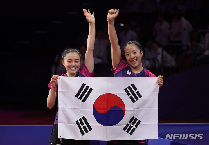 [항저우=뉴시스] 고승민 기자 = 2일 중국 항저우 공슈 캐널 스포츠파크 짐내시움에서 열린 2022 항저우 아시안게임 여자 탁구 복식 결승 한국 대 북한 경기, 세트스코어 4:1로 북한에 승리를 거두고 금메달을 획득한 전지희, 신유빈이 태극기를 들고 인사를 하고 있다. 2023.10.02. kkssmm99@newsis.com