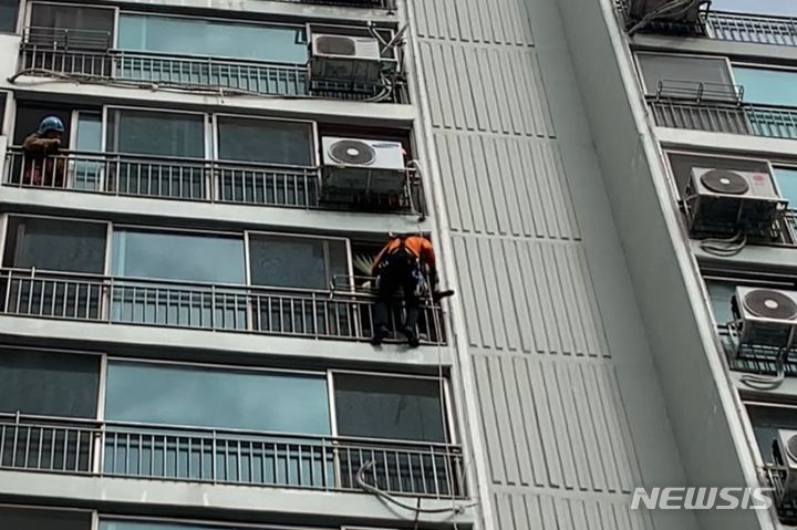 [김포=뉴시스] 이루비 기자 = 3일 오전 경기 김포시 감정동의 한 아파트에서 소방당국이 10층 베란다 난간에 앉아 있던 90대 치매 의심 노인을 구조하고 있다. (사진=김포소방서 제공) 2023.10.03. photo@newsis.com *재판매 및 DB 금지 