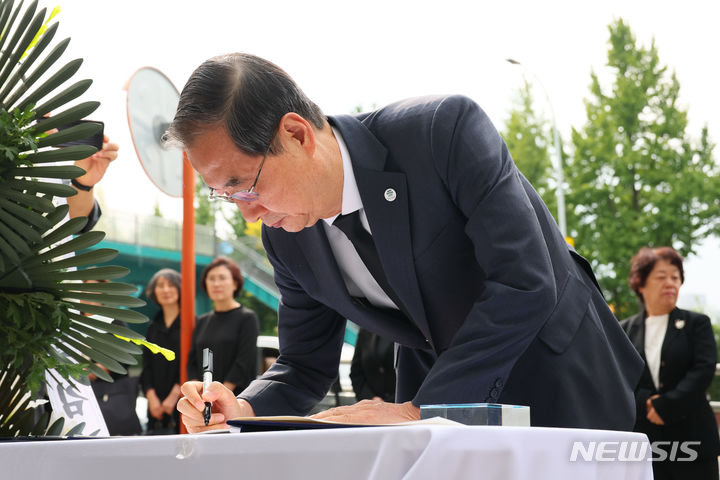 [서울=뉴시스]한덕수 국무총리가 10월 4일 대한간호협회관 앞에 마련된 고(故)마가렛 피사렉 간호사 분향소를 찾아 조문하고 조문록에 글을 남기고 있다. 총리실제공