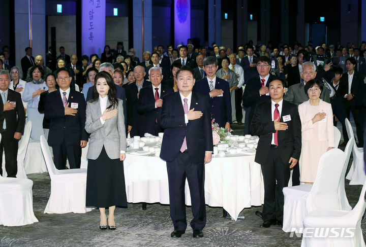 [서울=뉴시스] 전신 기자 = 윤석열 대통령과 부인 김건희 여사가 4일 서울 광진구 그랜드 워커힐 서울에서 열린 파독 근로 60주년 기념 오찬에서 국기에 대한 경례를 하고 있다. 2023.10.04. photo1006@newsis.com