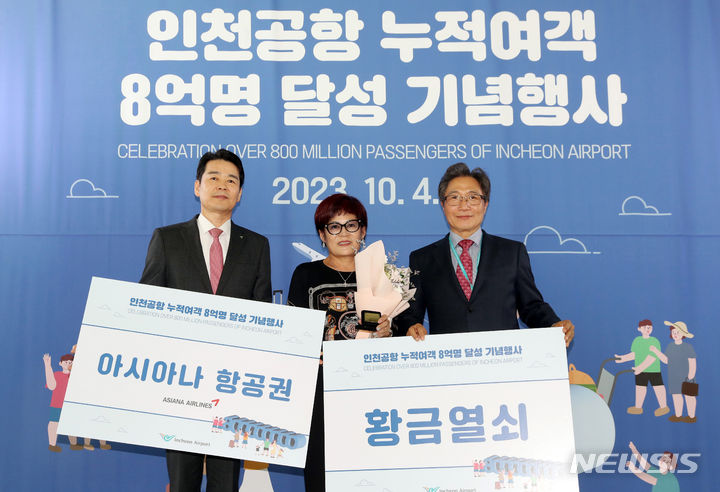 [인천공항=뉴시스] 공항사진기자단 = 이학재 인천국제공항공사 사장(오른쪽)과 현일조 아시아나항공 서비스본부장이 4일 오후 인천국제공항 제1여객터미널 탑승구 앞에서 열린 인천국제공항 누적 여객 8억 명 달성 기념행사에서 8억 번째 승객과 기념촬영을 하고 있다. 2023.10.04. photo@newsis.com