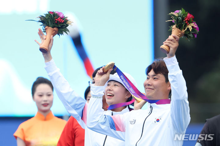 [항저우=뉴시스] 조수정 기자 = 4일 중국 항저우 푸양 인후 스포츠센터에서 열린 2022 항저우 아시안게임 양궁 혼성 리커브 결승 일본과의 경기 후 시상식에서 이우석과 임시현이 손을 흔들고 있다. 2023.10.04. chocrystal@newsis.com