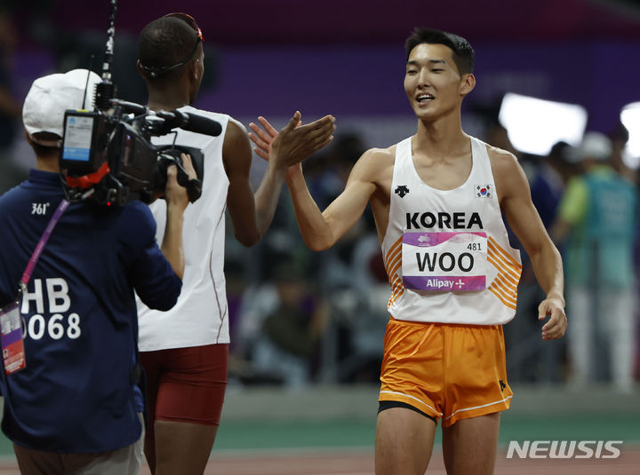[항저우=뉴시스] 정병혁 기자 = 4일 중국 항저우 올림픽 스포츠센터 스타디움에서 열린 2022 항저우 아시안게임 남자 높이뛰기 결선에서 은메달을 차지한 우상혁이 무타즈 에사 바르심과 인사를 나누고 있다. 2023.10.04. jhope@newsis.com