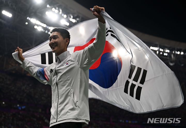 [항저우=뉴시스] 정병혁 기자 = 4일 중국 항저우 올림픽 스포츠센터 스타디움에서 열린 2022 항저우 아시안게임 남자 높이뛰기 결선에서 은메달을 차지한 우상혁이 태극기를 펼치고 있다. (공동취재사진) 2023.10.04. jhope@newsis.com